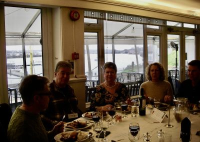 A group of East Coast Branch Moody Owners sitting at a lunch table in front of a window. The River Medway is visible through the window.